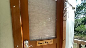 A wooden door with a frosted glass panel, a nameplate reading 'Horned Frog,' and a metal handle. - OT 3515H Texas Yurt Haus Horned Frog (New Braunfels)