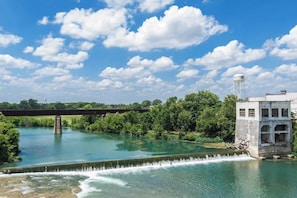 Un pont enjambant une rivière, avec une tour à eau et un bâtiment doté d’une décharge d’eau.