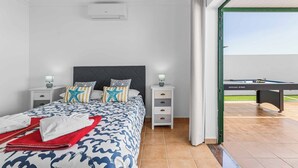 A bedroom with a bed, bedside tables, a lamp, and a pool table. - Villa Bonaci - Three Bedroom Villa, Sleeps 6 (Playa Blanca)