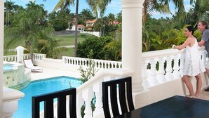 A poolside area with a clear view of a pool, palm trees, and a white balustrade. - Luxury all- inclusive villa w/ private chef (Puerto Plata)