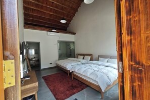 A bedroom with a wooden ceiling, a bed with white bedding, a red rug, and a small wooden table. - Jinjiawan Guesthouse (Yifeng)