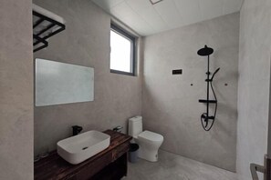 A modern bathroom with a large mirror, a white sink, a toilet, and a shower. - Jinjiawan Guesthouse (Yifeng)