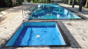 A swimming pool with a tiled deck and a drainage grate. - Ceylon Kingsmen Garden Hotel (Negombo)