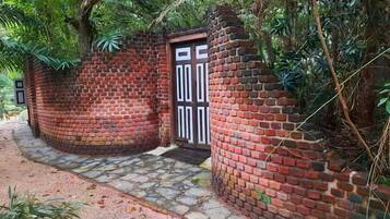A brick wall with a door, surrounded by greenery.