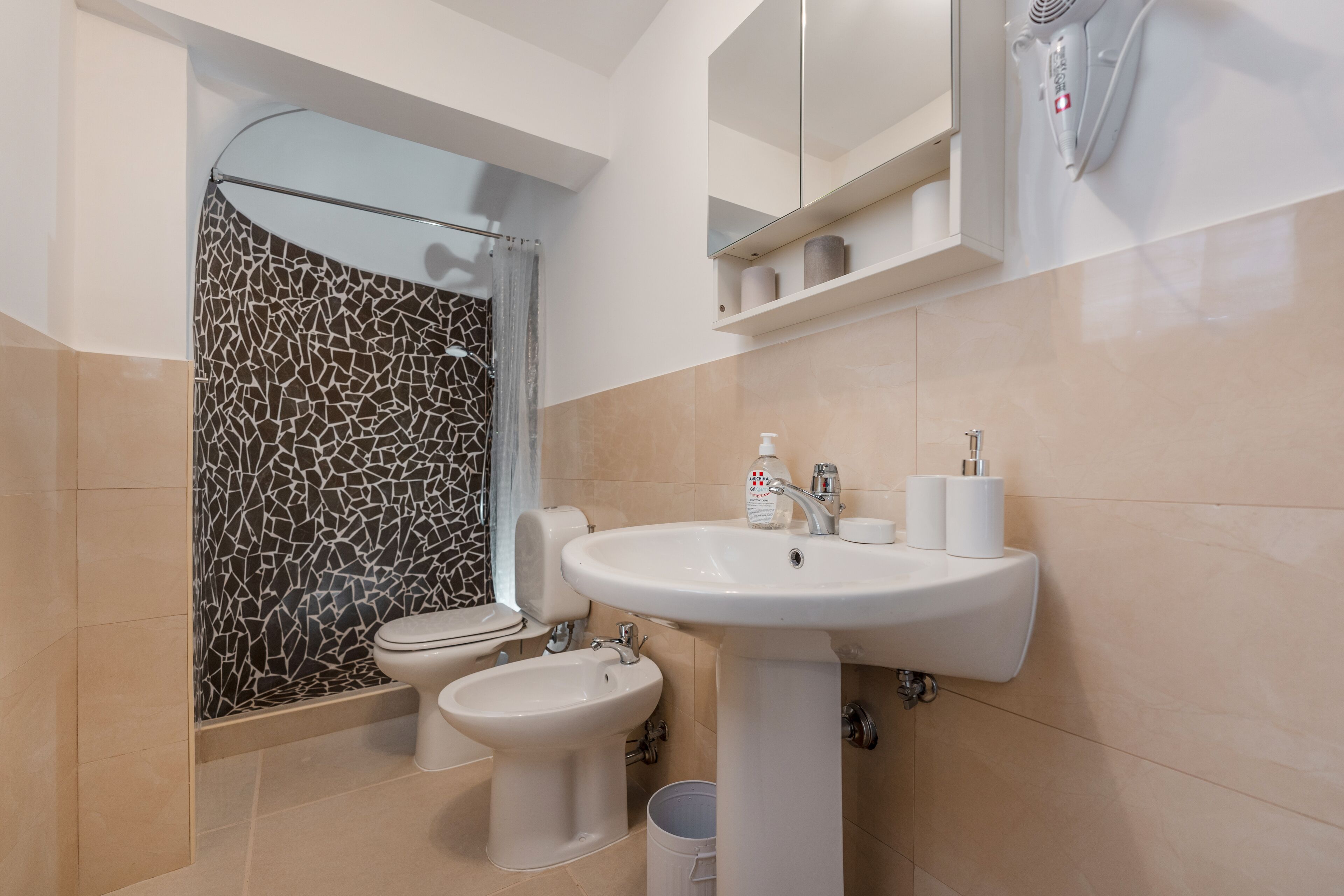 A bathroom with a toilet, bidet, and sink.