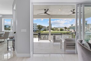 Un salón moderno con balcón, comedor y vistas a una zona residencial.