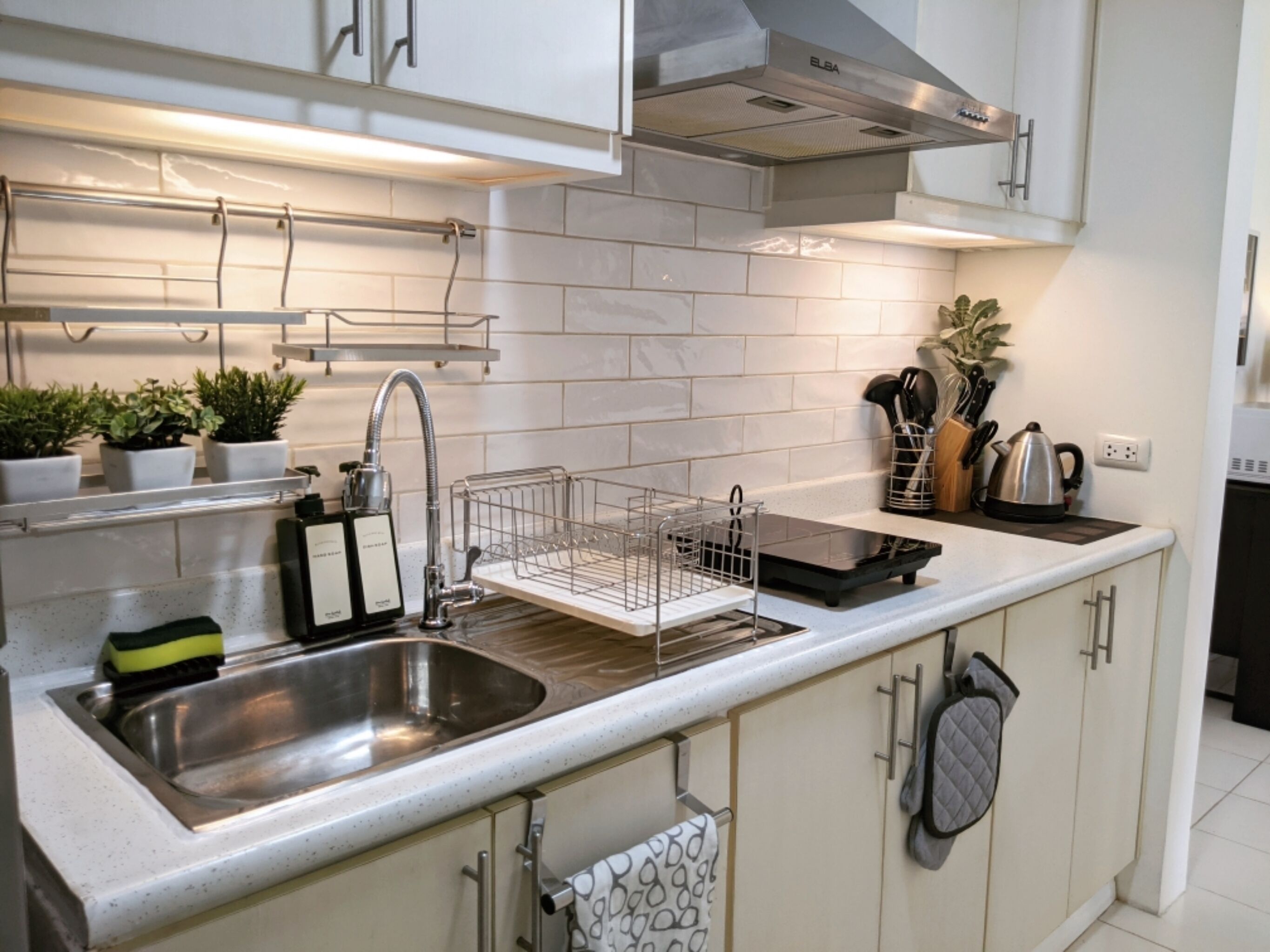 Een koelkast, een magnetron, een waterkoker, kookgerei, borden en bestek