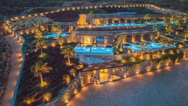 Vista aérea de un lujoso resort con varias piscinas, arquitectura de piedra y jardines paisajísticos.