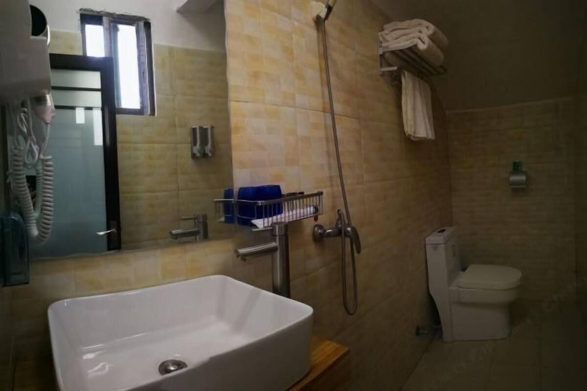 A bathroom with a white sink, a shower, and a toilet.