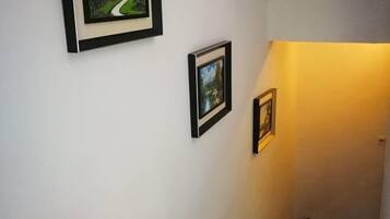Een gang met drie ingelijste foto's aan de muur.