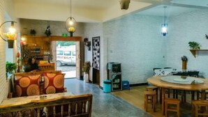 A restaurant with a brick wall, wooden furniture, and hanging lights. - Water Ink Yuanyang Hotel Yuanyang (Yuanyang)