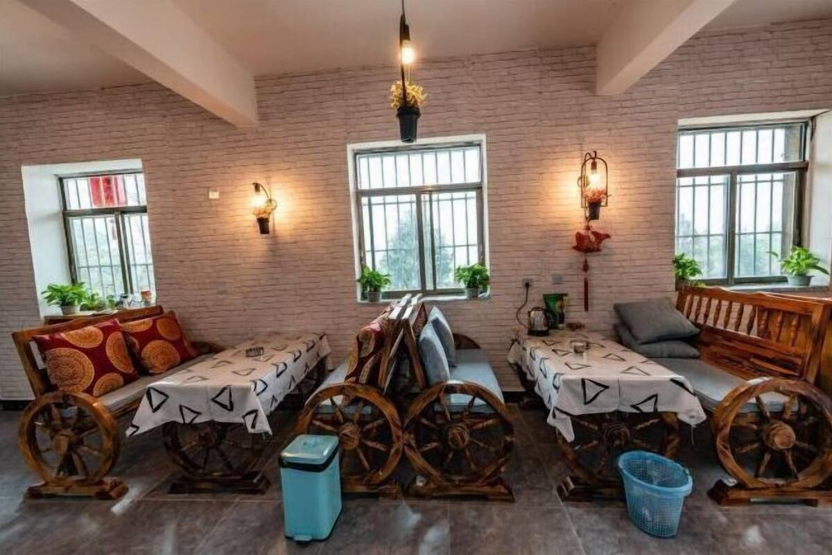 A rustic room with brick walls, wooden furniture, and large windows.