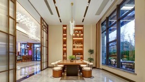 A modern dining area with a long table, cushioned chairs, and a central light fixture. - Jinjiang Metropolo Hotel (Yancheng Dafeng Changxin Road) (Yancheng)