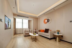 A modern living room with a sofa, a coffee table, and a wall-mounted artwork. - Jinjiang Metropolo Hotel (Yancheng Dafeng Changxin Road) (Yancheng)