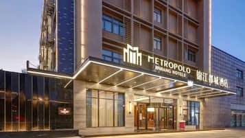 A hotel entrance with a modern facade, large glass windows, and a prominent signage.