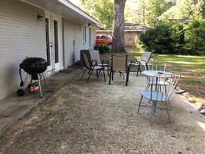 En terrasse med grill, stole og bord.