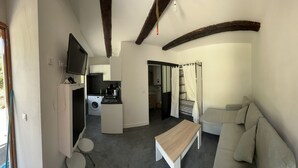 A compact living space with a kitchenette, a dining area, and a sofa. - Nice little studio in the Vésubie valley, Mercantour Park (Roquebillière)