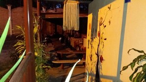 An outdoor covered area with a pathway, plants, a hanging light fixture, and a wheelchair accessibility sign. - Hotel Flor del Campo (Pedro Vicente Maldonado)