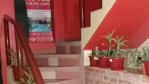 A staircase with red railings and potted plants. - Hotel Flor del Campo (Pedro Vicente Maldonado)