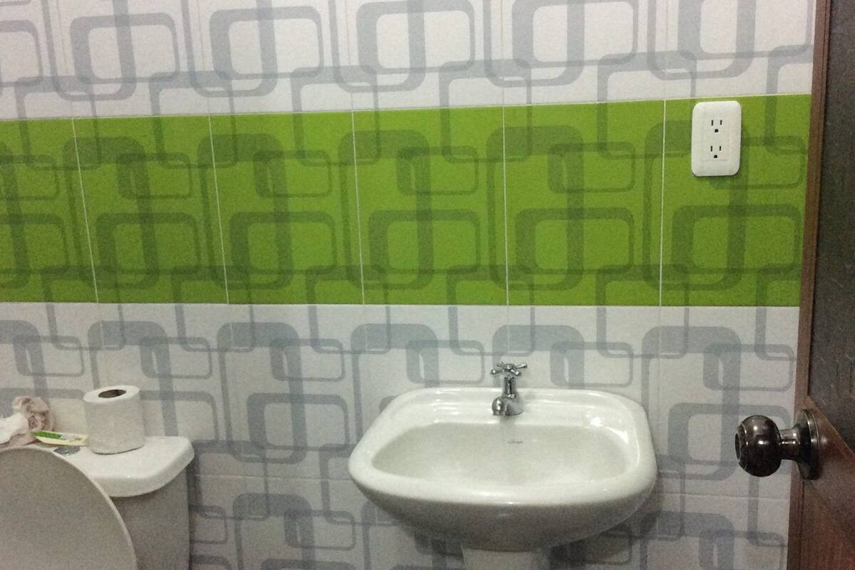 A bathroom with a toilet, a sink, and patterned tiles.