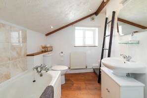 A modern bathroom with a bathtub, toilet, and sink. - Spacious Cottage, Parking nr Saunton Sands (Braunton)
