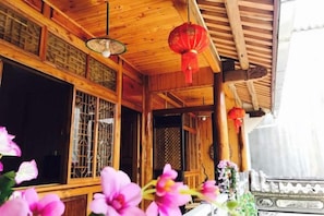 Una estructura de madera con elementos arquitectónicos chinos tradicionales, incluyendo celosías y farolillos rojos.