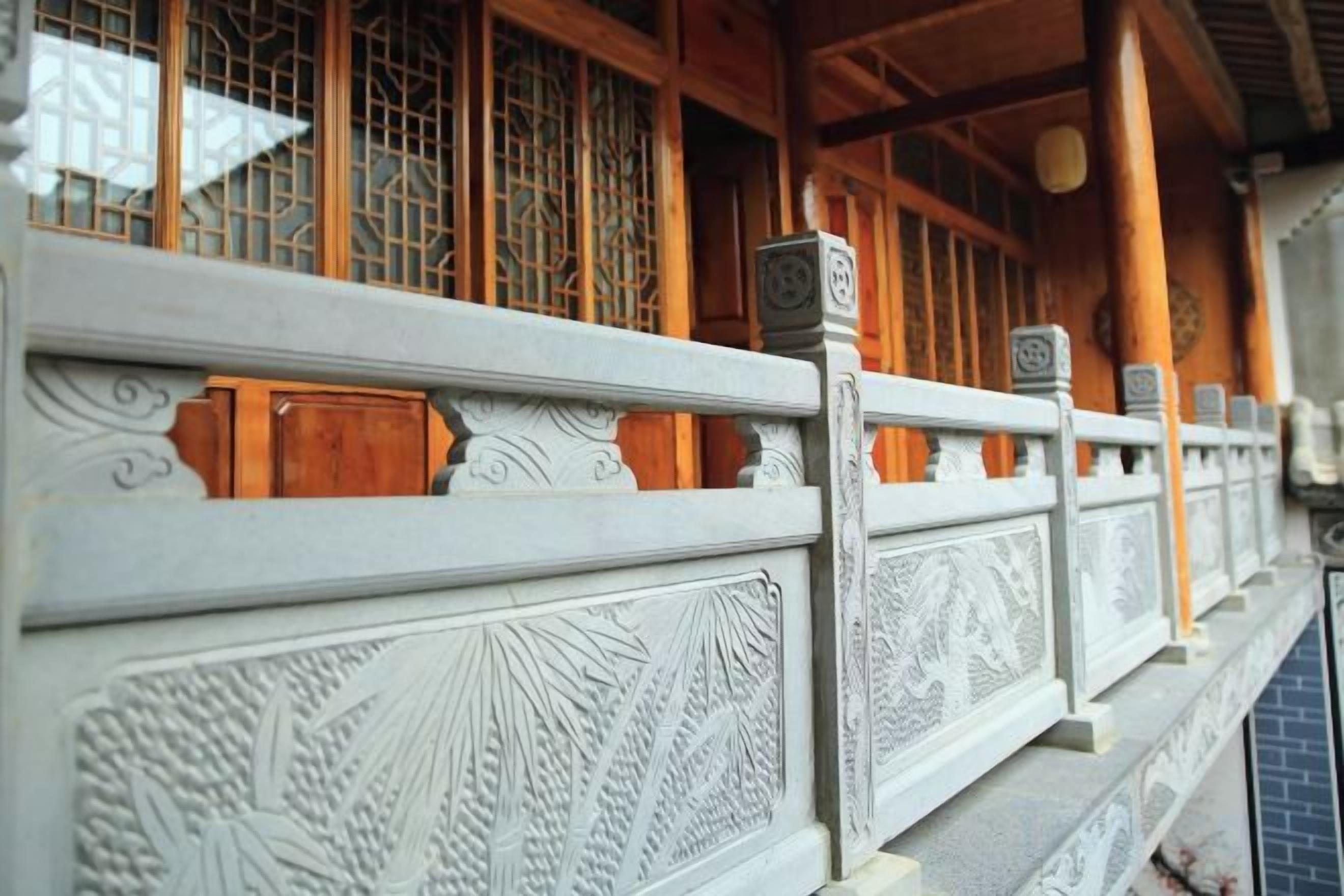 A traditional wooden building with intricate carvings on the railing and a tiled floor.
