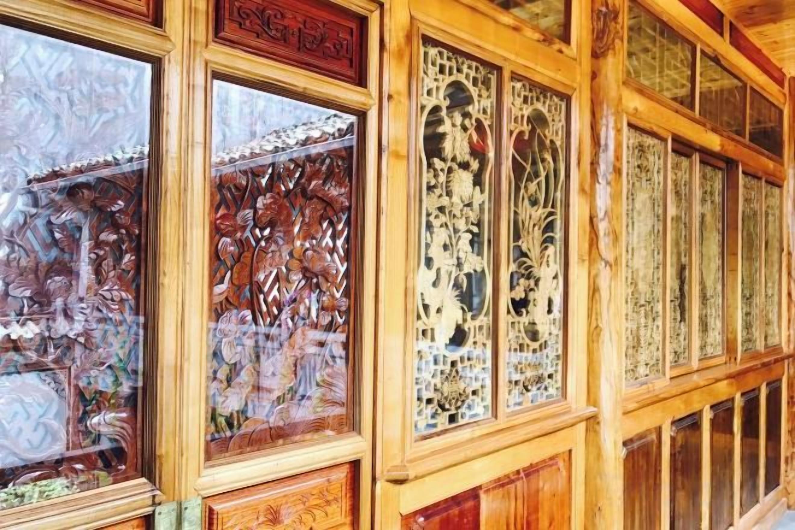 A wooden interior with intricate carvings on the walls and a series of windows.