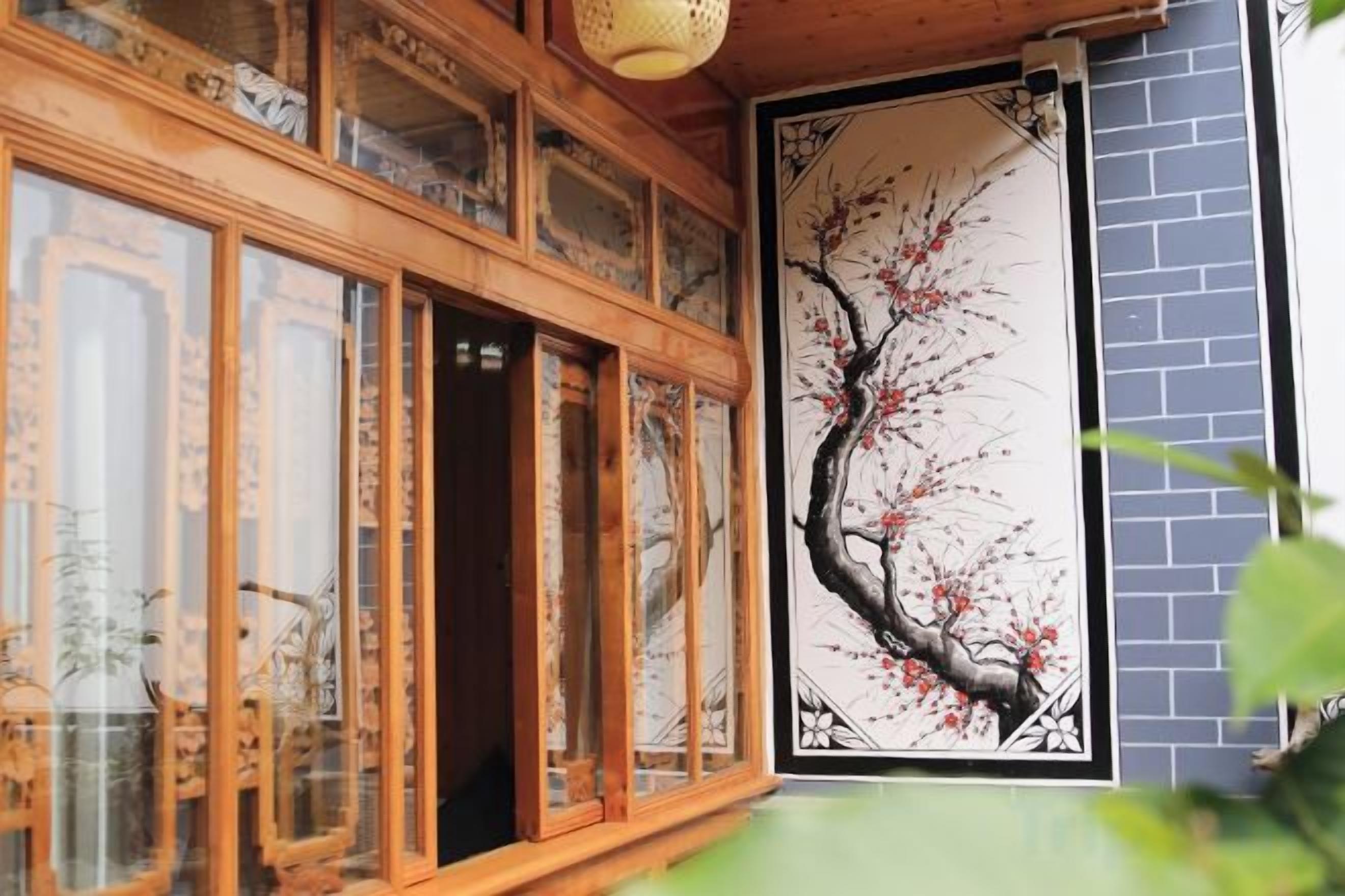 A traditional wooden structure with glass doors and a wall-mounted painting.
