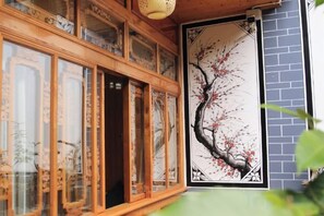 A traditional wooden structure with glass doors and a wall-mounted painting.