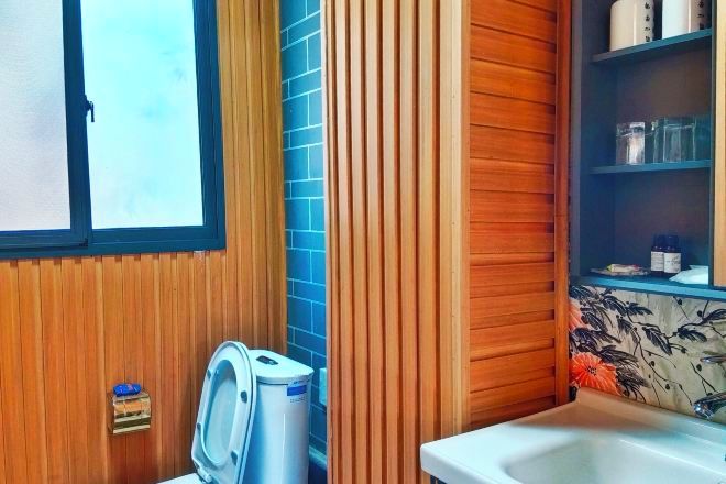 A bathroom with a wooden vanity, a sink, and a window.
