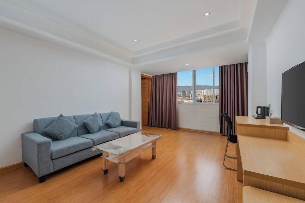 A modern living room with a sofa, coffee table, and a TV.