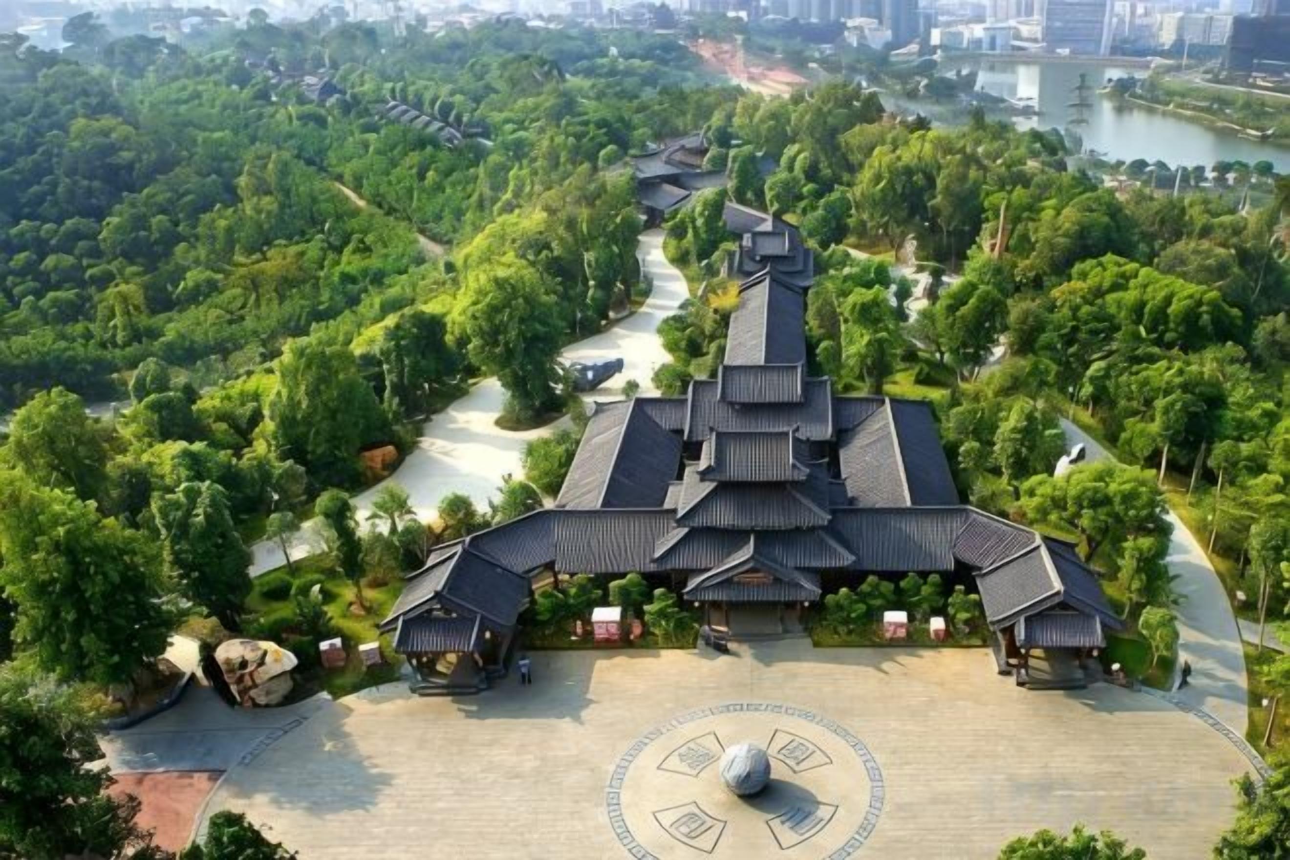 A traditional building with multiple pagoda-style roofs, surrounded by lush greenery and a river.