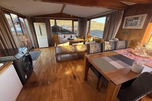 A compact room with a dining table, sofa, and a washing machine. - Lijiang Chenjie Inn (Sifang Street Branch) (Lijiang)