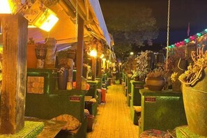 A narrow corridor with green planters and numbered signs, likely indicating a market or shop area. - Lijiang Chenjie Inn (Sifang Street Branch) (Lijiang)