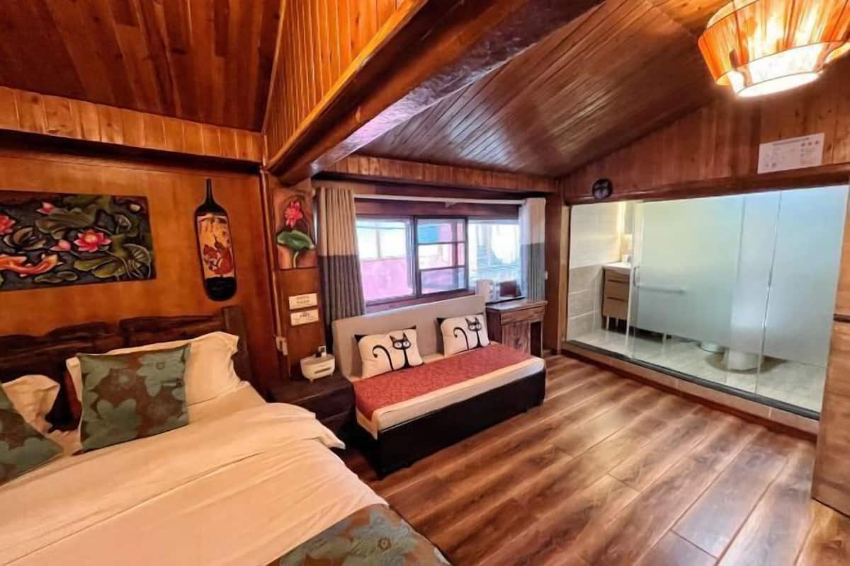 A wooden room with a bed, a bench, a window, and a mirror.