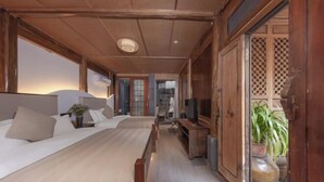 Quarto com cama, televisão e porta de madeira com design treliçado.