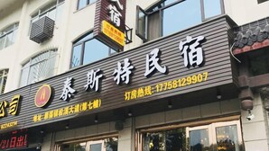 Un hotel con un letrero que muestra el nombre y la información de contacto.