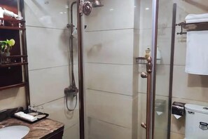 Une salle de bain moderne avec une douche à parois de verre, un comptoir en marbre et un porte-serviettes.