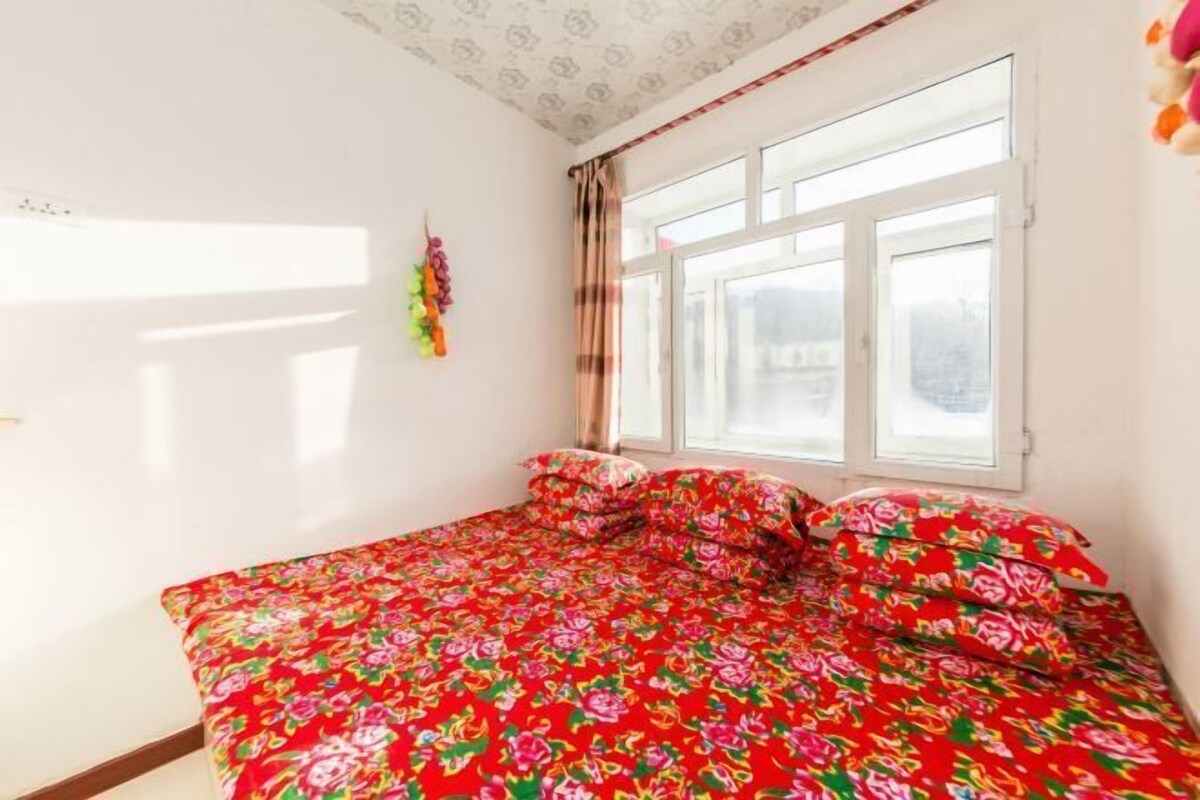 A room with a bed, a window, and a wall decoration.