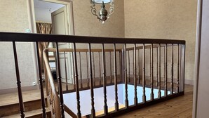 Una escalera de madera con piso de vidrio que da a una plataforma.