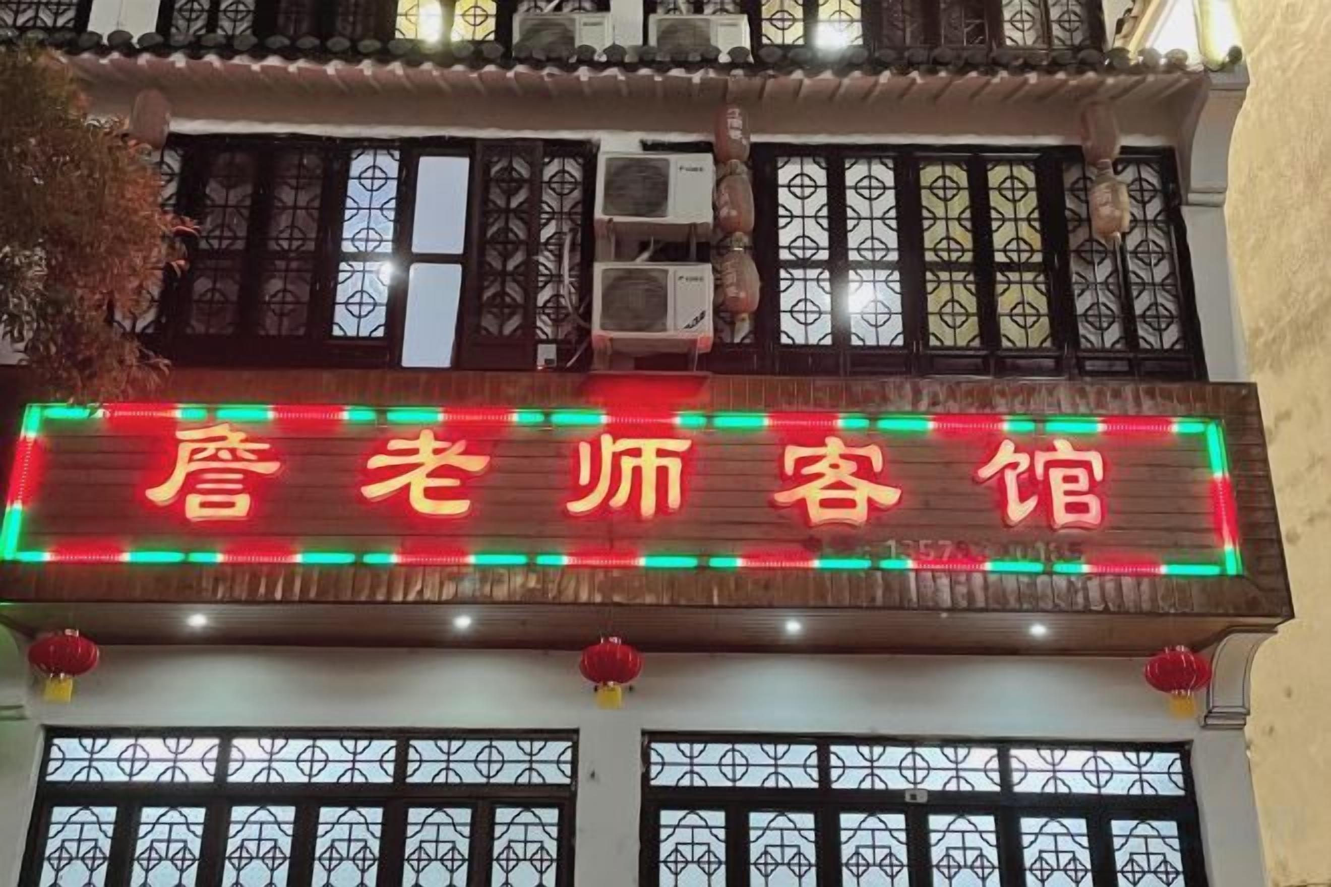 A building with a neon sign in red and green colors.