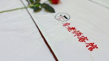 A white tablecloth with red Chinese characters and a red rose.