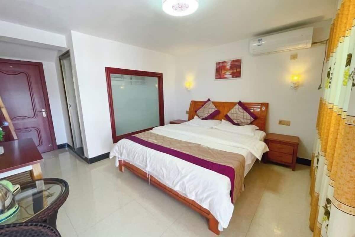 A bedroom with a bed, bedside tables, a wardrobe, and a mirror.