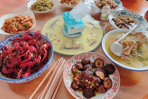 A table with various dishes, including seafood and vegetables. - Zhanlaoshi Hostel (Wuyuan)