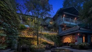 A traditional courtyard with a building, seating area, and a small water feature. - Qingcheng Mountain Yiyuanju Bieyuan Hostel (Dujiangyan)
