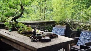 A wooden table with a tray of tea set and a bonsai tree. - Qingcheng Mountain Yiyuanju Bieyuan Hostel (Dujiangyan)