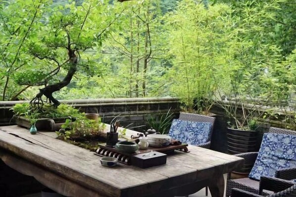 A wooden table with a tray of tea set and a bonsai tree. - Qingcheng Mountain Yiyuanju Bieyuan Hostel (Dujiangyan)