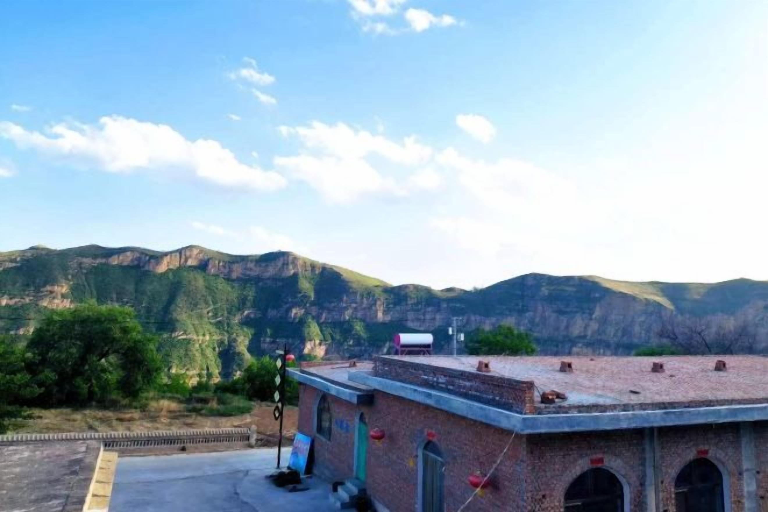 Un edifici amb façana de maó, teulada plana i cel serè.