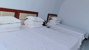 Habitación de hotel con cama, mesita de noche y espejo.